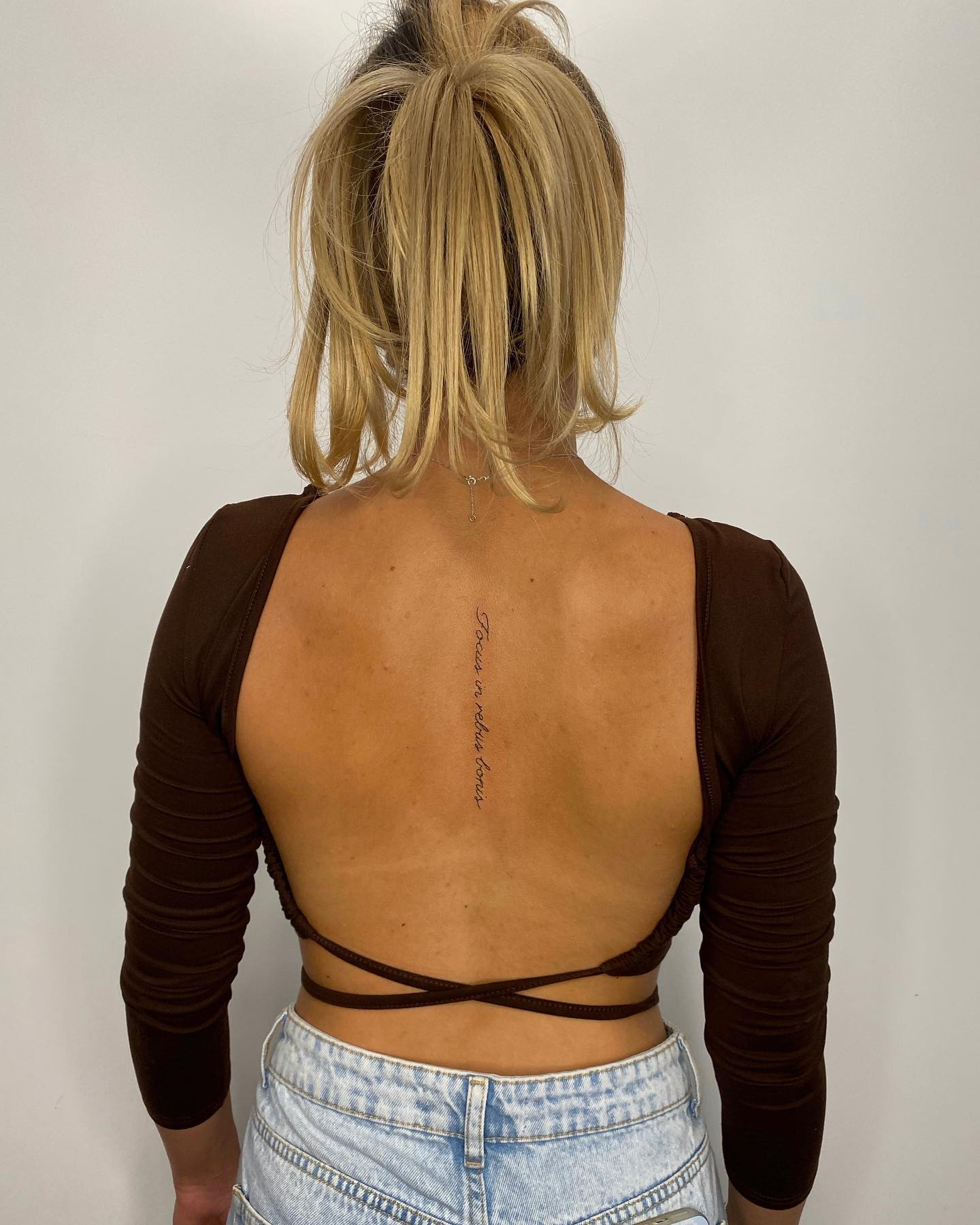 A small and simple back tattoo across your spine will make you look like a feminine lady.