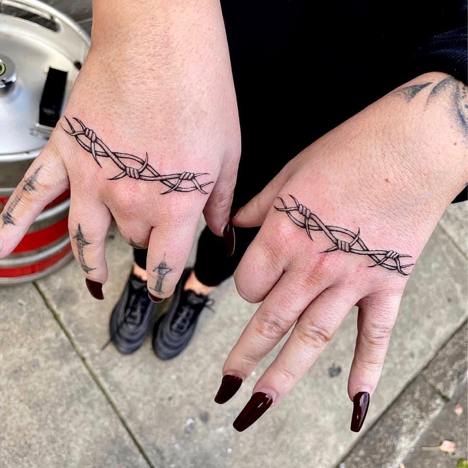 The old school feel that barbed wire tattoos create is just amazing. To show your love of old school vibes, you should try this arm tattoo. One short strip barbed wire on each hand is quite matching. Plus, the dark nailpolish looks amazing with it.