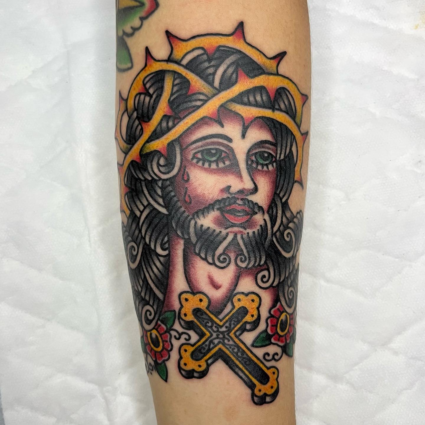 This animated Jesus tattoo are for those who like things that are animated. Plus, all of this design has an old school vibe because of the colors used and flowers below the Jesus. If you want to get a detailed cross tattoo, this is the one to go for.