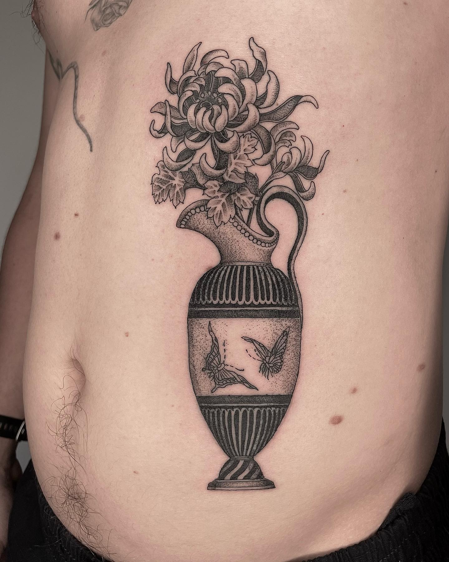 This shady-looking vase tattoo looks stunning with its details. Plus, butterflies have a positive meaning of rebirth, joy and beauty.