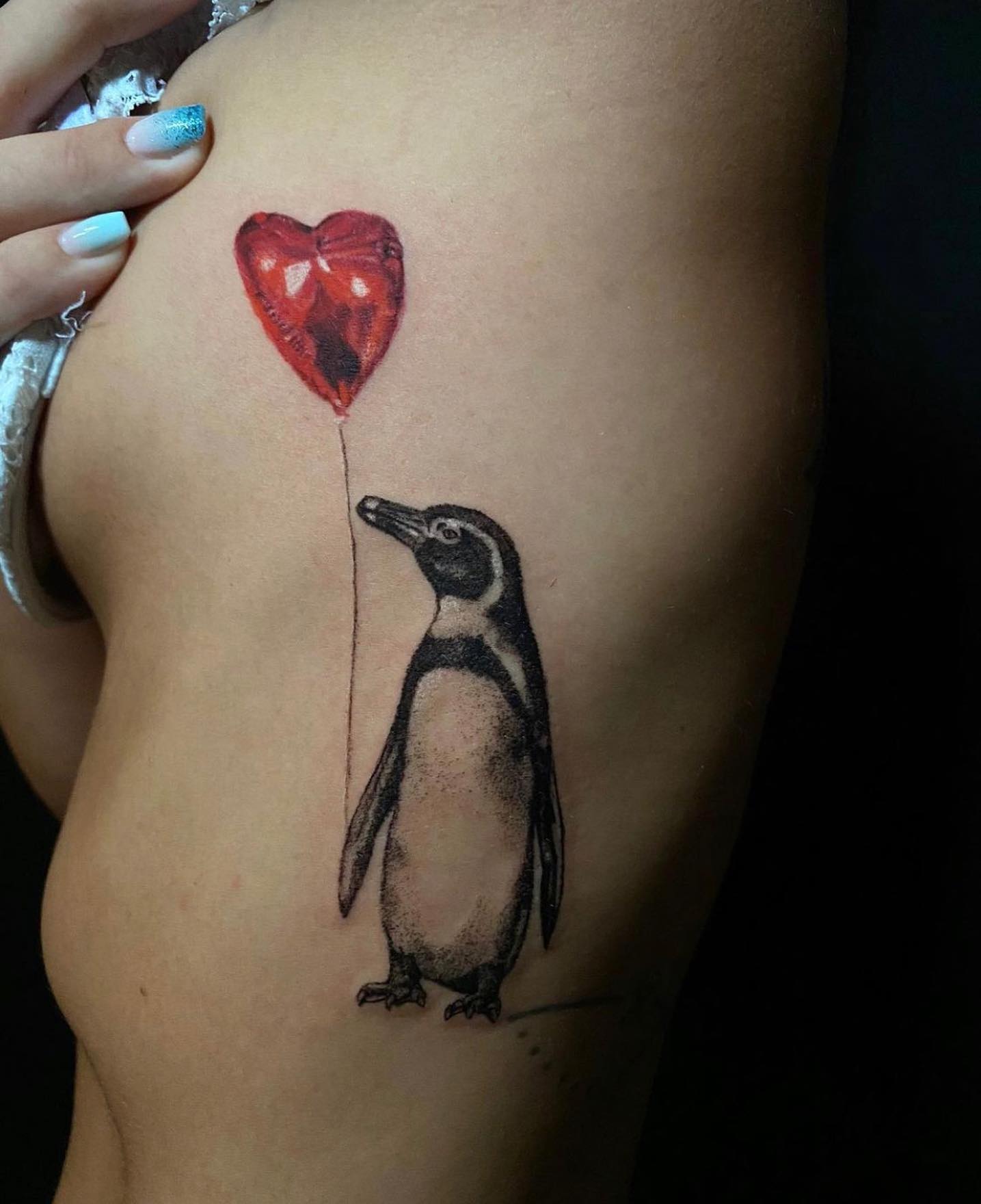 A lonely penguin holding a heart shaped flying balloon looks like a great tattoo. If you feel like this penguin, don't wait too long to get it.
