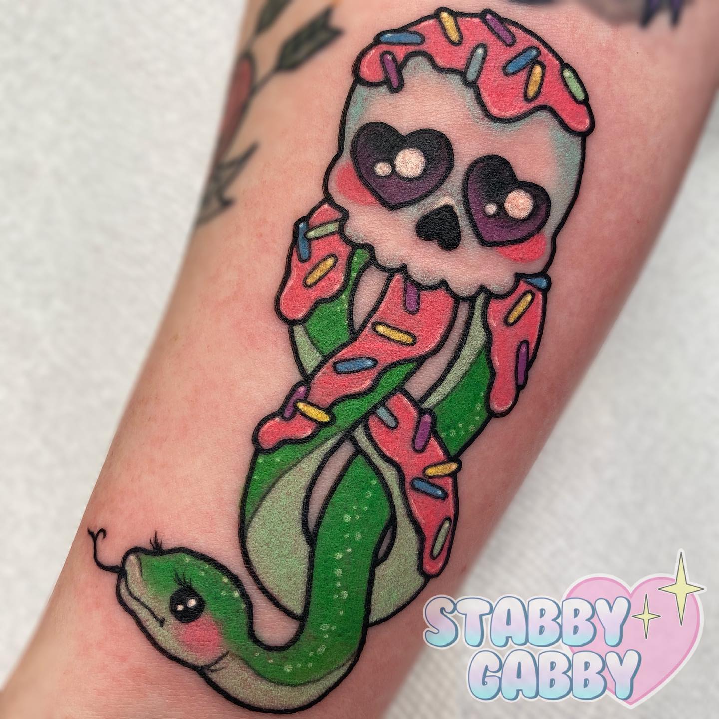 Death eaters are scary and dark, right? In this tattoo, it's the opposite because creativity talks in tattoos! A cute death eater tattoo is full of pink, a skull with hearts and a cute snake with eyelashes. It doesn't look scary at all.