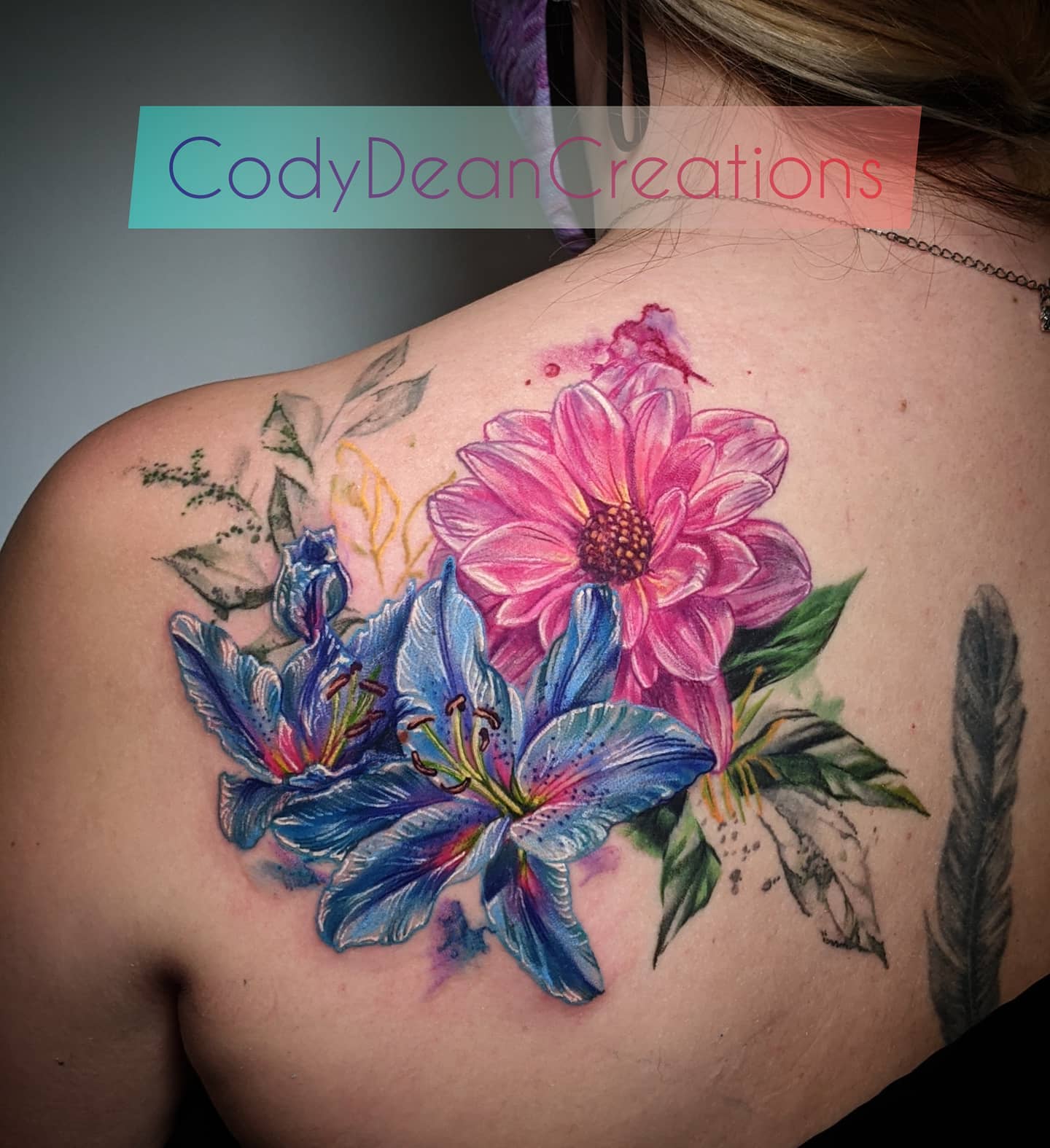 To have fun with your back, here is a great tattoo for you. The pink and blue lilies are so beautiful and they remind a garden full of flowers. It's great that they also look like something more abstract, like a piece of art!