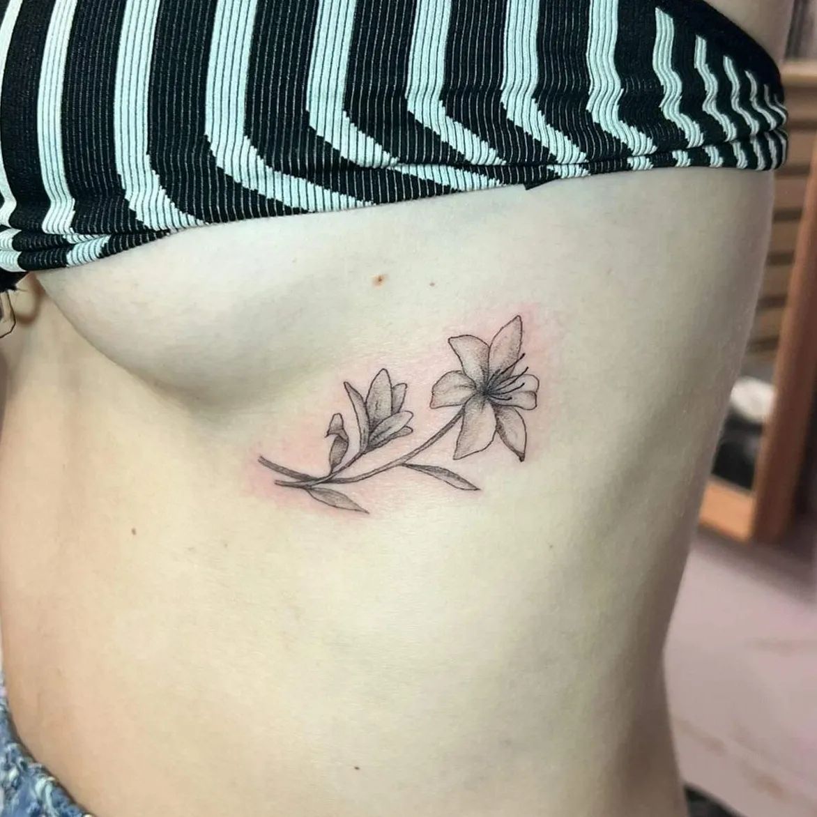 Want to try something that is super-sexy? Then, blackwork lily tattoo which is placed just below your breast is definitely for you. Whenever you raise your arms, your fabulous lily tattoo will be revealed and everyone will be amazed with it.